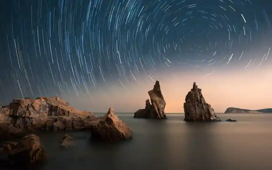4k星轨壁纸-夜空轨迹和礁石-延迟摄影免费下载「哲风壁纸」